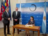 La canciller Mondino firma el libro de visitas de la OCDE, junto a Quirno y Cormann